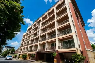 Jomtien Beach Penthouses: Exterior view of the multi-story building with numerous balconies from street level.