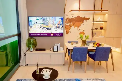 1 Bedroom Condo for Sale at Once Wong Amat living and dining area with wall-mounted TV and world map feature wall