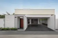 3 Bedroom House for Sale at Zensiri Lakeside Pool Villas modern exterior facade with decorative block wall, wooden front door, and carport