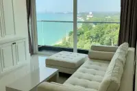 2 Bedroom Condo for Sale at Del Mare living room with tufted cream sofa and stunning panoramic sea and beach view