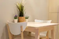 1 Bedroom Condo for Sale at Veranda Residence Pattaya compact dining area with light wood table white chairs and potted plants