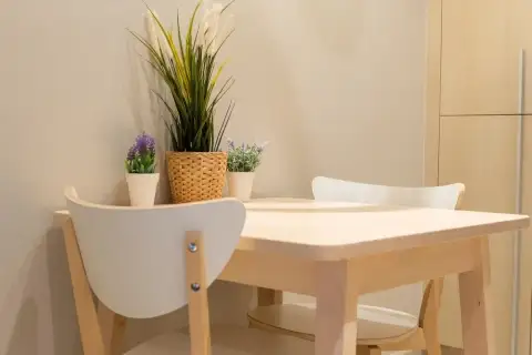 1 Bedroom Condo for Sale at Veranda Residence Pattaya compact dining area with light wood table white chairs and potted plants