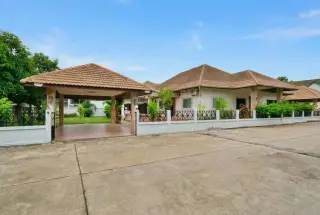 Srisuk Villa private swimming pool with outdoor daybed, lush green plants, and a shaded seating area.