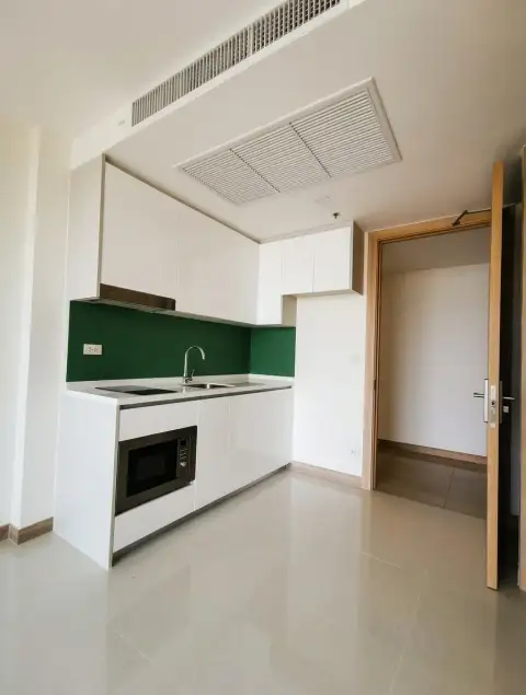 1 Bedroom Condo for Sale at The Riviera Jomtien kitchen with dark green backsplash beside bedroom doorway