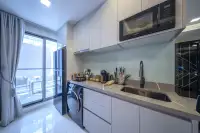 1 Bedroom Condo for Sale at Grand Solaire Noble modern kitchen with grey countertop, Samsung microwave, washing machine, and balcony access