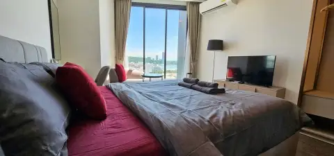 1 Bedroom Condo for Sale at EDGE Central Pattaya bedroom with city view through window and TV console