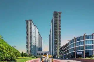 The Twin Tower Jomtien Beach Pattaya street-level front view of two soaring condo towers with landscaped driveway and golden angel statue