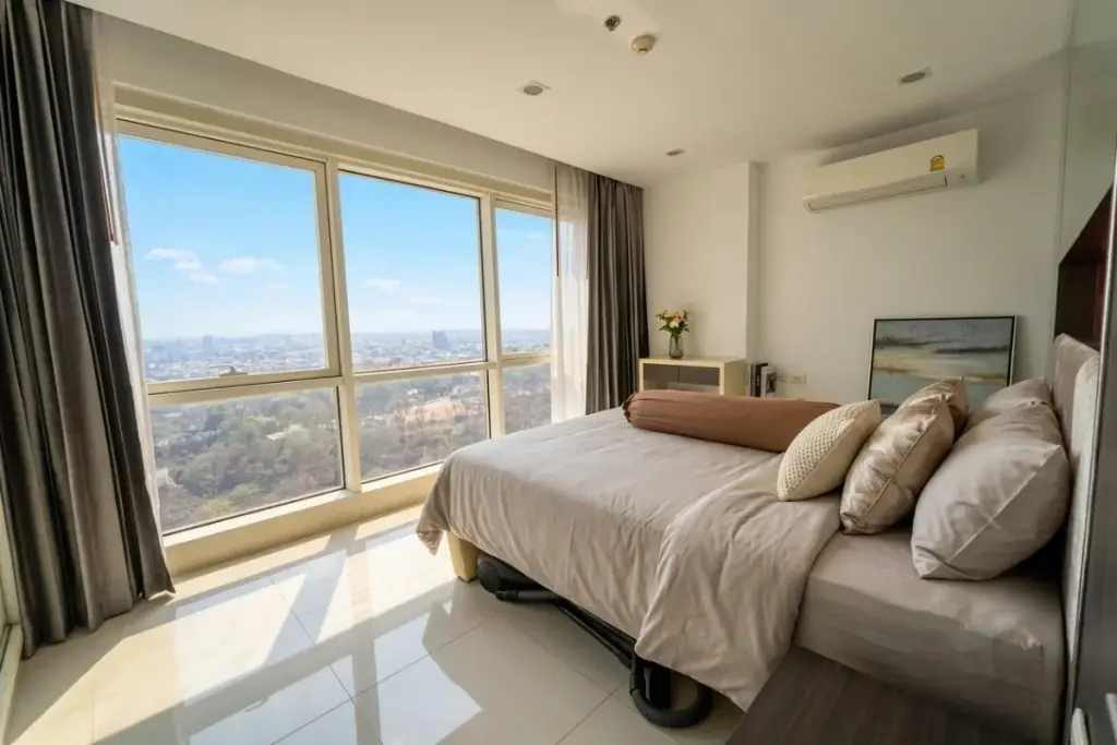 1 Bedroom Condo for Sale at The Vision open-plan living area with blue sofa, black coffee table, TV, and kitchen.