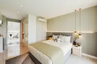 Studio Condo for Sale at The Coral Pattaya: Studio layout showing bed, TV, and compact kitchen area.