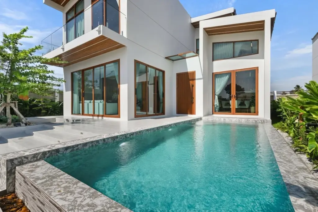 Atmos Prime: Modern white house exterior with private swimming pool and wooden framed glass doors.