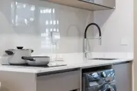 1 Bedroom Condo for Sale at Aquarous Jomtien Pattaya modern kitchen with white marble countertop, induction hob, black faucet and Samsung washing machine