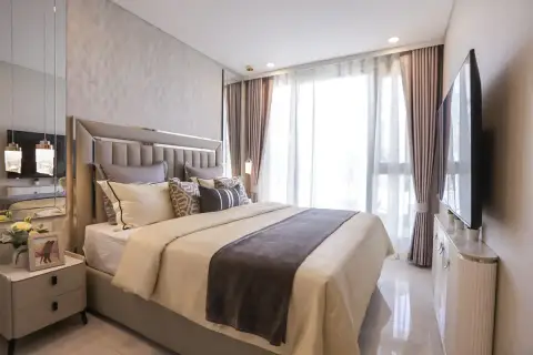 1 Bedroom Condo for Sale at Copacabana Coral Reef master bedroom with tall padded headboard, wall TV and floor-to-ceiling curtains