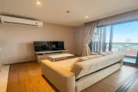 1 Bedroom Condo for Rent at Once Pattaya bright living room with large sofa, flat-screen TV, and floor-to-ceiling windows overlooking city