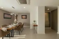 3 Bedroom Condo for Sale at Zensiri Estates and Residences formal dining area with wooden table, velvet chairs, gold chandelier, and hallway