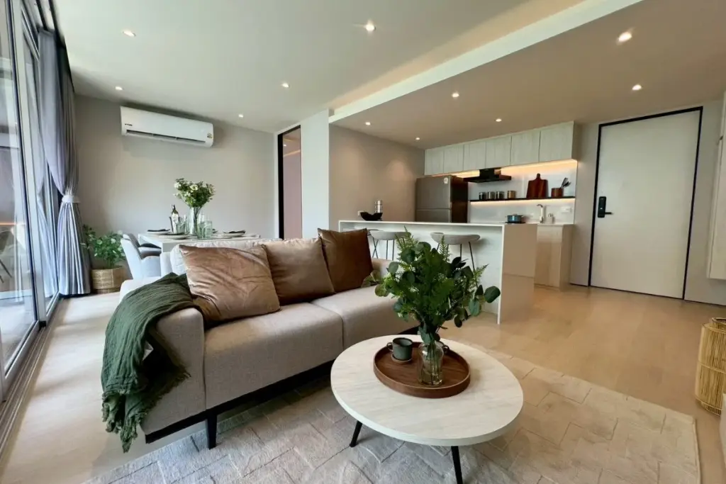 2 Bedroom Condo for Sale at Celine Wongamat living area with sofa, coffee table, dining table, and modern kitchen.
