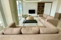 3 Bedroom Condo for Sale at Del Mare bright living area with L-shaped sofa, black coffee table, and ocean views through glass doors