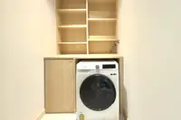 1 Bedroom Condo for Rent at Movenpick Residences laundry area with a white front-load washing machine and shelving.