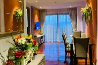 2 Bedroom Condo for Sale at The Senate Residences living room with TV unit, hardwood floors, floral decor, and balcony sea view