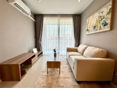 1 Bedroom Condo for Sale at Atlantis Condo Resort living room with beige sofa and balcony access