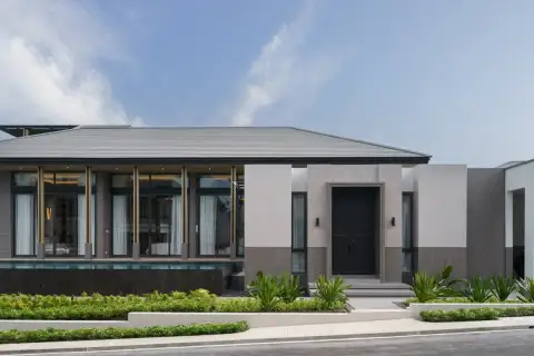 4 Bedroom House for Sale at Cascade front facade close-up showing black entry door, gold-trimmed columns, floor-to-ceiling glazing, and tropical landscaping