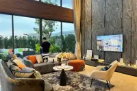 4 Bedroom House for Sale at Highbury Hill Pool Villas Pattaya spacious living room with dark stone feature wall and floor-to-ceiling windows