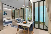 1 Bedroom Condo for Sale at Once Wong Amat: Dining area with table set, living room sofa, and bedroom visible through glass partition.
