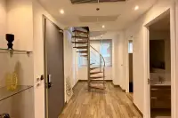 4 Bedroom Condo for Sale at Cetus Beachfront entry hallway with spiral staircase and wood-look tile flooring