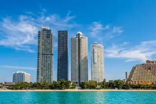 Sky Beach condominium building with curved balconies, a swimming pool, and a white gazebo.