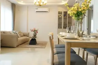 Phonthep Garden Ville 2 open-plan living and dining area with chandelier, beige sofa, and wood dining table set