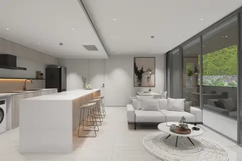 2 Bedroom Condo for Sale at Celine Wongamat open-plan kitchen with white island, bar stools, and living room with garden balcony