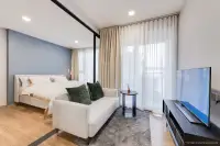 1 Bedroom Condo for Sale at Aquarous Jomtien Pattaya bedroom with blue accent wall, double bed, sofa, flat-screen TV and balcony