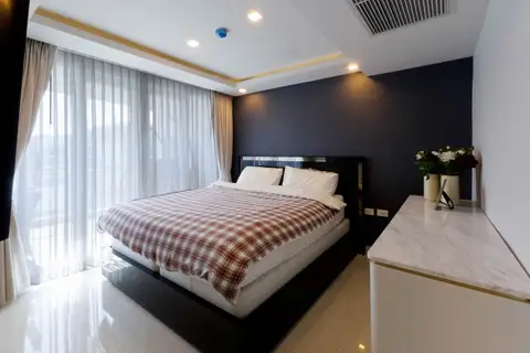 2 Bedroom Condo for Sale at Grand Avenue Residence: Bedroom with large bed, checkered duvet, and sheer curtains.