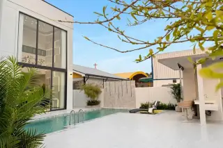 AVANI Pool Villa modern exterior with white and grey facade, carport, and two luxury cars parked in front.