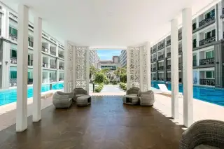 Dusit Grand Park 2 open-plan living room and dining area, with a bedroom visible through a doorway.