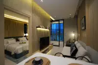 1 Bedroom Condo for Sale at SKYPARK Lucean Jomtien Pattaya evening view of living and bedroom area with wood slat walls and city view balcony