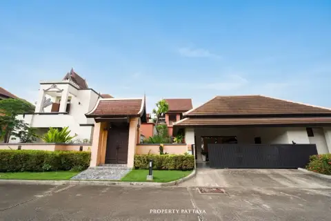 Phutara front exterior of a house with traditional Thai-style roof, wooden entrance gate, and garage door.