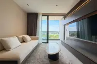 1 Bedroom Condo for Rent at Panora Estuaria bright living room with cream sofa, oval coffee table and floor-to-ceiling balcony doors with green view