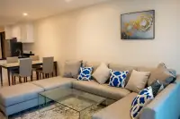 2 Bedroom Condo for Sale at The Elegance open-plan living room with L-shaped sofa, glass coffee table and dining area