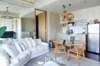 2 Bedroom Condo for Sale at Veranda Residence Pattaya living room with white sofa, dining table, and compact kitchen.