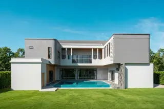 My Room Pool Villa - Pattaya - Modern house exterior with swimming pool, large glass doors, and green lawn.