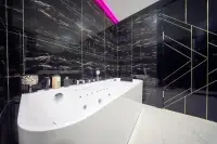 2 Bedroom Condo for Sale at Grand Solaire Noble en-suite bathroom close-up of white jacuzzi tub with black marble surround and gold trim