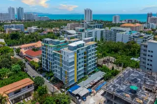 Estanan Condo: Modern building facade with green, white, and yellow panels, large windows, and balconies.