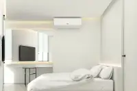 2 Bedroom Condo for Sale at Secret Garden Condominium, bedroom with bed, wall-mounted AC unit, and vanity with mirror.
