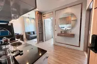 2 Bedroom Condo for Sale at The Twin Tower Jomtien Beach Pattaya interior view of kitchen and entryway with round mirror and living area beyond