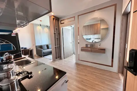 2 Bedroom Condo for Sale at The Twin Tower Jomtien Beach Pattaya interior view of kitchen and entryway with round mirror and living area beyond