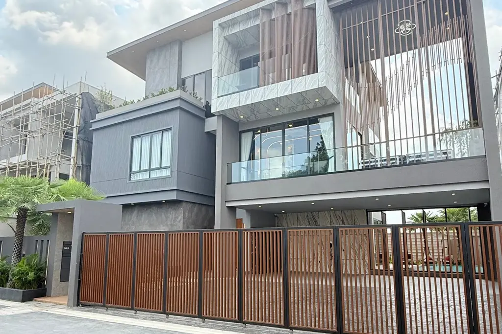 5 Bedroom House for Sale at Harmony Hills Villas Pattaya modern facade with wooden slat details and private gate.