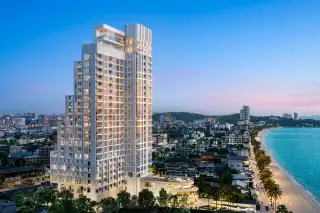 PTY Residence Sai 1 modern white high-rise building illuminated at dusk, overlooking Pattaya city and coastline.