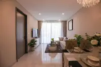 2 Bedroom Condo for Sale at Copacabana Coral Reef living room with L-shaped sofa, flat-screen TV, and floor-to-ceiling sheer curtains