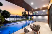 8 Bedroom House for Sale in Nong Prue, outdoor patio with lounge chairs overlooking a long pool at sunset.