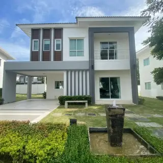 Lanceo NOV Pattaya modern twin houses with covered parking, green lawn, and children playing.